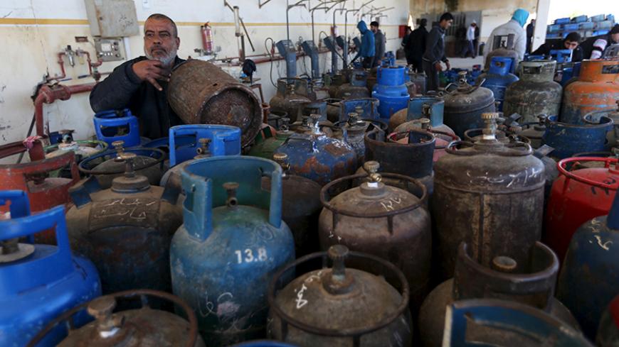 A Palestinian worker fills a cooking gas canister at a gas filling station in Rafah in the southern Gaza Strip January 28, 2016. The strip, home for 1.95 million people, has been experiencing a shortage of cooking gas, local residents said. REUTERS/Ibraheem Abu Mustafa  - RTX24E0B