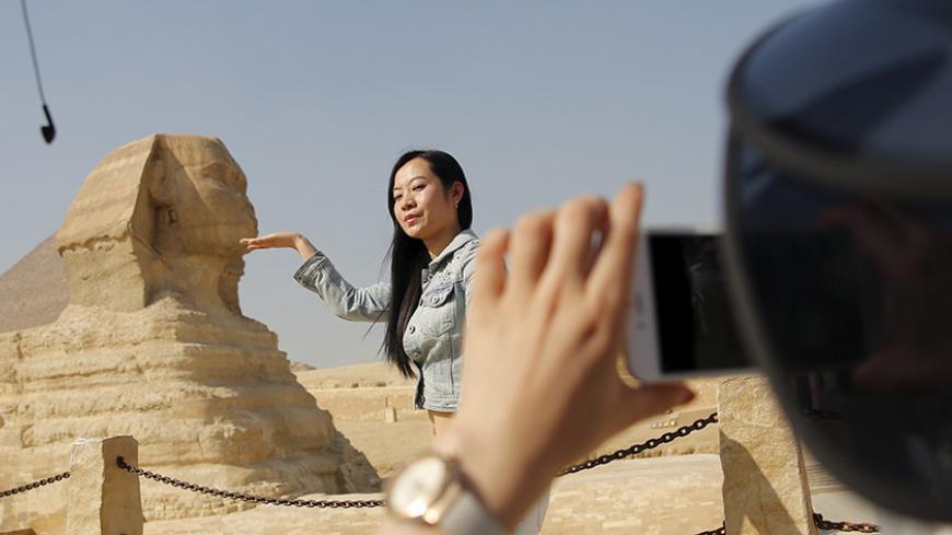 A Chinese tourist poses for a photo in front of the Sphinx at the Giza Pyramids on the outskirts of Cairo, Egypt March 2, 2016. REUTERS/Amr Abdallah Dalsh - RTX29A7C