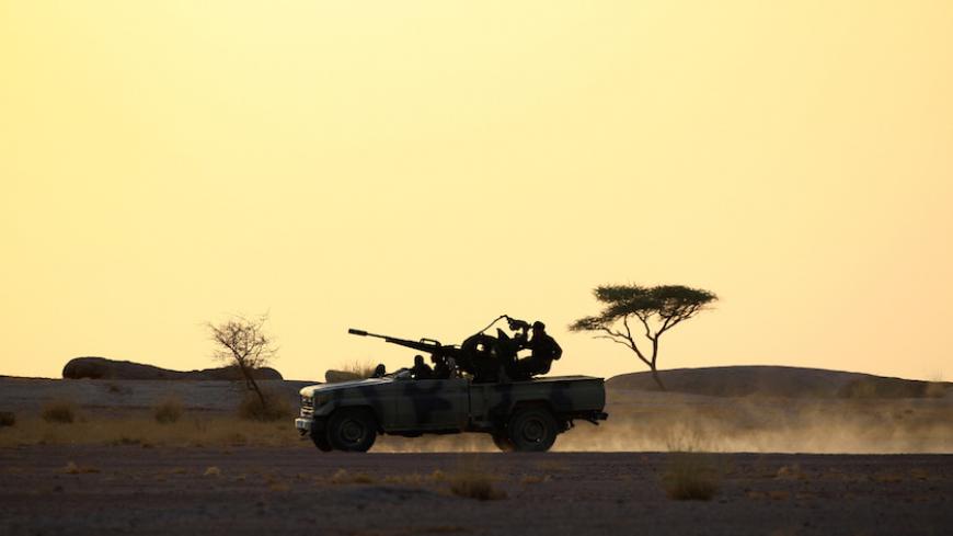 The Polisario Front soldiers drive a pick-up truck mounted with an anti-aircraft weapon during sunset in Bir Lahlou, Western Sahara, September 9, 2016. REUTERS/Zohra Bensemra          SEARCH ìPOLISARIOî FOR THIS STORY. SEARCH "WIDER IMAGE" FOR ALL STORIES.     - RTX2RO75