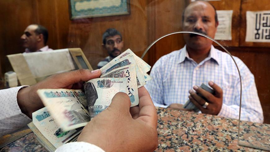 An employee counts Egyptian pounds in a bank in Cairo, Egypt, November 3, 2016. REUTERS/Mohamed Abd El Ghany - RTX2RPB3