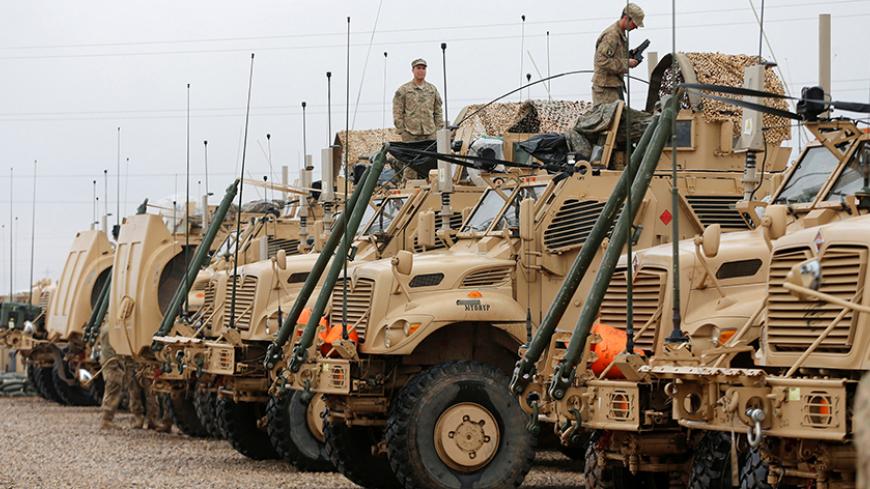 U.S. soldiers gather near military vehicles at an army base in Karamless town, east of Mosul, Iraq, December 25, 2016. Picture taken December 25, 2016. REUTERS/Ammar Awad - RTX2WHHJ