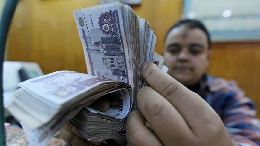 An employee counts Egyptian pounds in a foreign exchange office in central Cairo, Egypt December 27, 2016. REUTERS/Mohamed Abd El Ghany - RTX2WLN5
