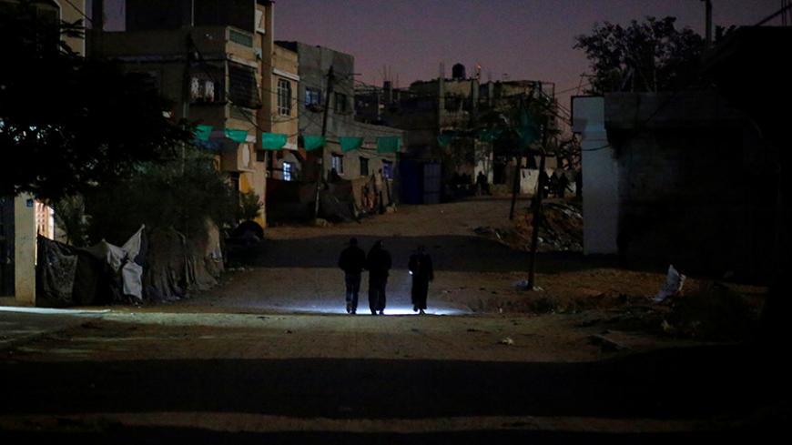 Palestinians walk on a road during a power cut in Beit Lahiya in the northern Gaza Strip January 11, 2017. Picture taken January 11, 2017. REUTERS/Mohammed Salem - RTX2YNDC