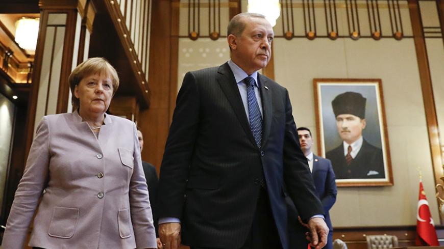 Turkish President Recep Tayyip Erdogan and German Chancellor Angela Merkel walk past a picture of Turkish Republic state founder Kemal Atatuerk before their bilateral meeting at the presidential palace during the first visit since July's failed coup in Ankara, Turkey, February 2, 2017.      REUTERS/Umit Bektas      TPX IMAGES OF THE DAY - RTX2ZBPW
