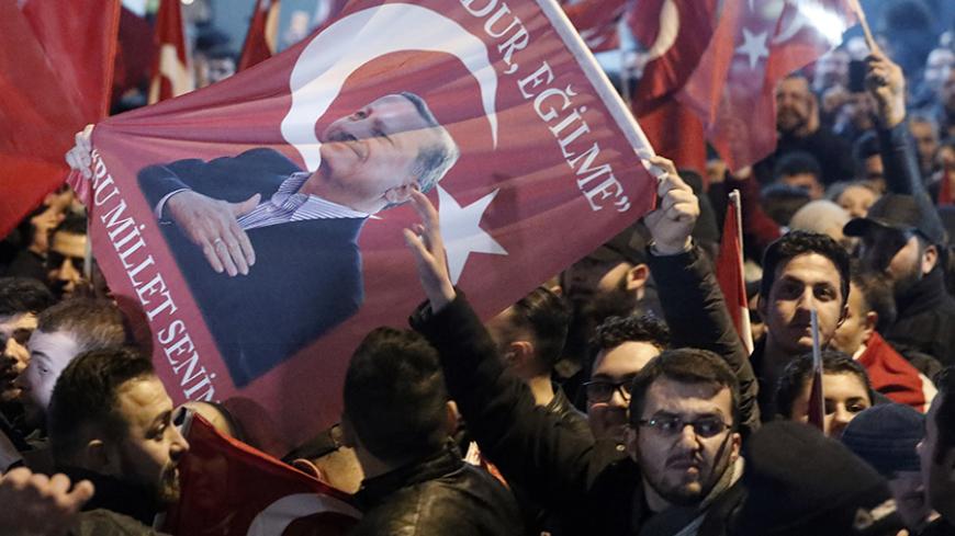Demonstrators with banners of Turkish President Recep Tayyip Erdogan gather outsidethe Turkish consulate to welcome the Turkish Family Minister Fatma Betul Sayan Kaya, who decided to travel to Rotterdam by land after Turkish Foreign Minister Mevlut Cavusoglu's flight was barred from landing by the Dutch government, in Rotterdam, Netherlands March 11, 2017.     REUTERS/Yves Herman - RTX30MBC