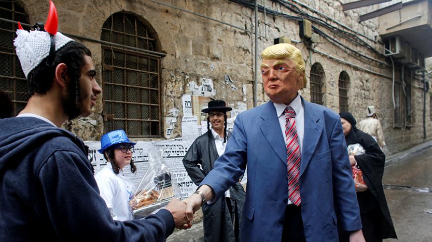 A person wearing a costume of U.S. President Donald Trump shakes hands with an ultra-Orthodox Jewish man during an annual parade marking the Jewish holiday of Purim, in Jerusalem March 13, 2017. REUTERS/Nir Elias     TPX IMAGES OF THE DAY - RTX30SHZ