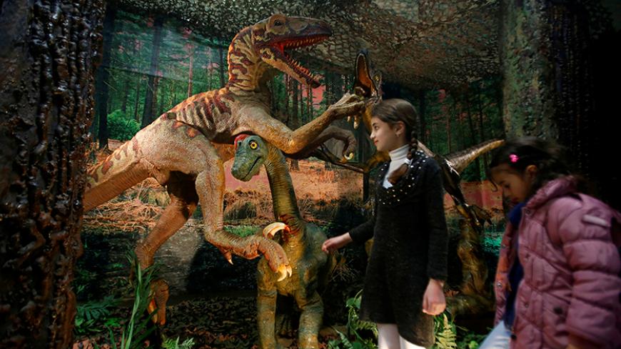 Palestinian children look at models of dinosaurs, which were donated by Henry Lowe to Bethlehem-Bath Links, during the opening of a dinosaur exhibition arranged by a Bath charity in the West Bank city of Bethlehem March 14, 2017. REUTERS/Mussa Qawasma - RTX3107J