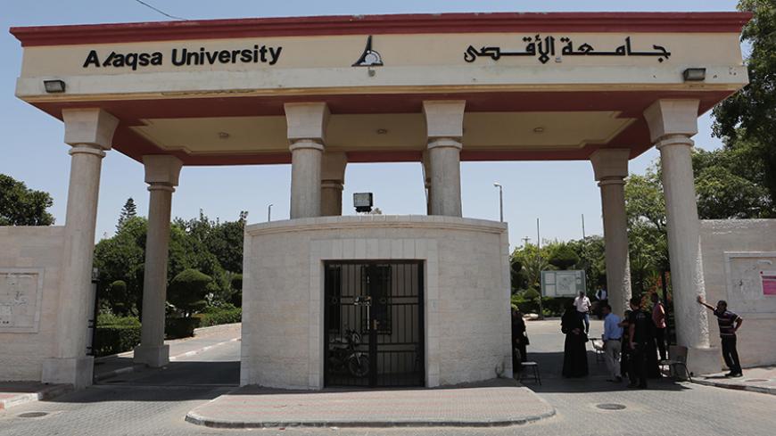 Palestinian men stand outside the gates of the al-Aqsa University built on what formerly was the Jewish settlement of Neve Dekalim, close to Khan Yunis, in the southern Gaza Strip, on August 11, 2015. Following the departure of the last Jewish settlers from Gaza in August 2005, the Israeli army demolished houses and dismantled its equipment before formally handing over the land to the Palestinian Authority. AFP PHOTO/ SAID KHATIB        (Photo credit should read SAID KHATIB/AFP/Getty Images)