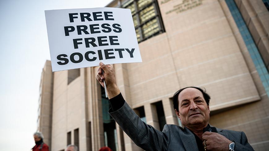 TOPSHOT - A demonstrator holds a placard reading "Free Press Free Society", outside the Istanbul courthouse on April 1, 2016, where Turkish opposition Cumhuriyet daily's editor-in-chief Can Dundar and Ankara bureau chief Erdem Gul attend their trial.
Cumhuriyet daily's editor-in-chief Can Dundar and Ankara bureau chief Erdem Gul face possible life terms on spying charges over a news report accusing President Recep Tayyip Erdogan's government of seeking to illicitly deliver arms bound for neighbouring Syria.