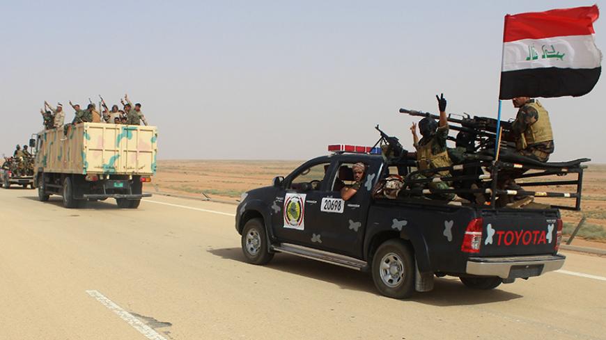 Iraqi government forces and local tribal fighters drive on the highway between the city of Ramadi and the town of Rutba as they take part in an operation to retake Rutba from the Islamic State jihadist group on May 16, 2016.
Special forces, soldiers, police, border guards and pro-government paramilitaries are involved in the operation to retake the Anbar province town, which has been held by the jihadist group since 2014, Iraq's Joint Operations Command said. / AFP / MOADH AL-DULAIMI        (Photo credit sh
