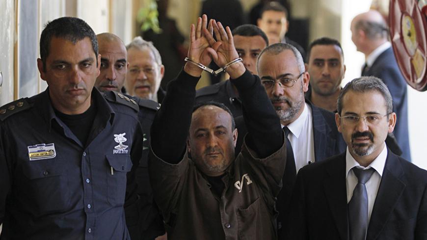 An Israeli prison guard escorts jailed Fatah leader Marwan Barghouti (C) to a deliberation at Jerusalem Magistrate's court January 25, 2012. Convicted of murder for his role in attacks on Israelis, Barghouti was jailed for life by Israel in 2004. 
REUTERS/Baz Ratner (JERUSALEM - Tags: POLITICS CRIME LAW) - RTR2WTIC