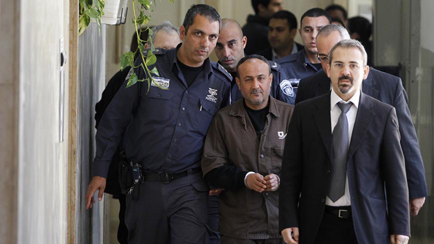 An Israeli prison guard (L) escorts jailed Fatah leader Marwan Barghouti (C) to a deliberation at Jerusalem Magistrate's court January 25, 2012. Convicted of murder for his role in attacks on Israelis, Barghouti was jailed for life by Israel in 2004. 
REUTERS/Baz Ratner (JERUSALEM - Tags: POLITICS CRIME LAW) - RTR2WTJR