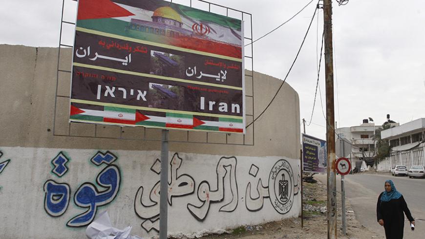 A Palestinian woman walks next to a banner that reads "Thanks and gratitude to Iran" in Gaza City November 27, 2012. Senior Hamas leader Mahmoud al-Zahar showed how fragile the ceasefire between Israel and Palestinians remained, with defiant remarks to reporters recently of how the Islamists would go on smuggling in weapons "by all possible means", including via Israel's arch-foe Iran. REUTERS/Ahmed Zakot (GAZA - Tags: CIVIL UNREST CONFLICT) - RTR3AXK0