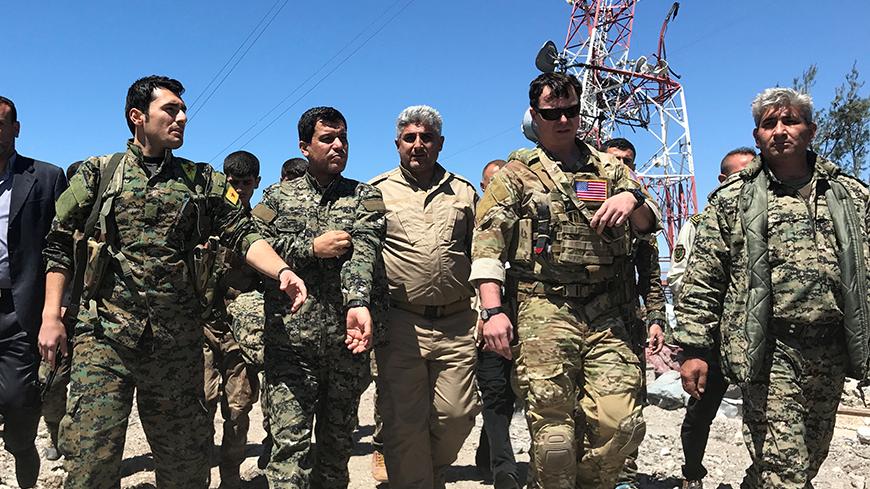 A U.S. military commander (2nd R) walks with Kurdish fighters from the People's Protection Units (YPG) at the YPG headquarters that was hit by Turkish airstrikes in Mount Karachok near Malikiya, Syria April 25, 2017. REUTERS/Rodi Said - RTS13T7Q