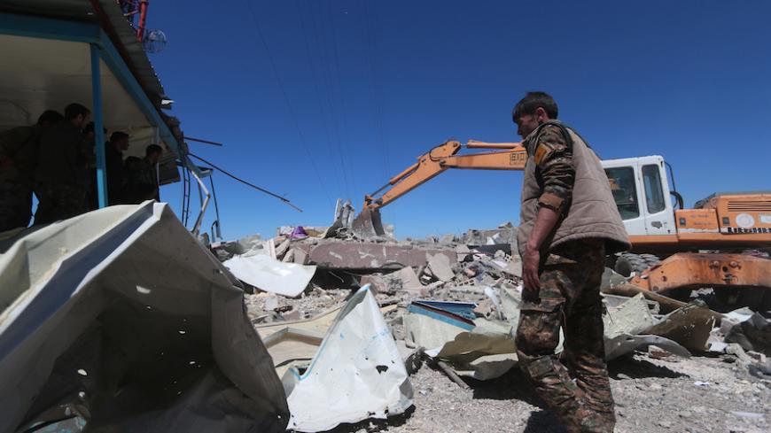 Members of the Kurdish People's Protection Units (YPG) inspect the damage at their headquarters after it was hit by Turkish airstrikes in Mount Karachok near Malikiya, Syria April 25, 2017. REUTERS/ Rodi Said - RTS13V4H