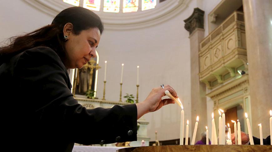 A woman lights a candle in memory of Italian PhD student Guilio Regeni, who was tortured and killed in the capital in January, at Saint Joseph's Roman Catholic Church in Cairo, Egypt March 5, 2016. REUTERS/Mohamed Abd El Ghany - RTS9EQL