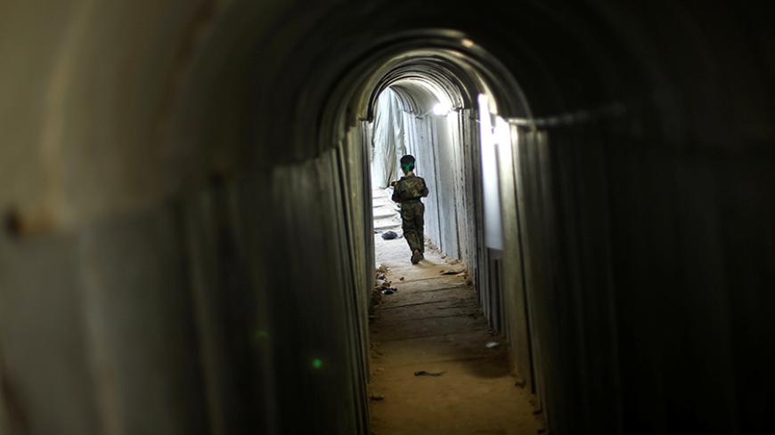 A Palestinian boy walks in a tunnel as he takes part in a military exercise graduation ceremony at a summer camp organised by Hamas's armed wing, east of Gaza City July 22, 2016. REUTERS/Mohammed Salem - RTSJ8Z8