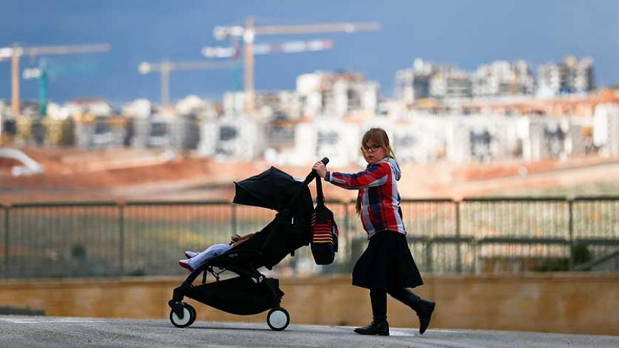 A girl pushes a stroller on a road in the Israeli settlement of Beitar Illit in the occupied West Bank February 15, 2017. REUTERS/Amir Cohen      TPX IMAGES OF THE DAY - RTSYS6S