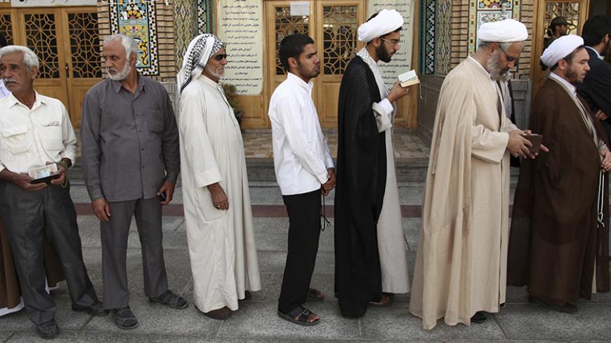 Men stand in line to vote during the Iranian presidential election at a mosque in Qom, 120 km (74.6 miles) south of Tehran June 14, 2013. Millions of Iranians voted to choose a new president on Friday, urged by Supreme Leader Ayatollah Ali Khamenei to turn out in force to discredit suggestions by arch foe the United States that the election would be unfair. REUTERS/Fars News/Mohammad Akhlagi  (IRAN - Tags: POLITICS ELECTIONS) ATTENTION EDITORS - THIS IMAGE WAS PROVIDED BY A THIRD PARTY. FOR EDITORIAL USE ON