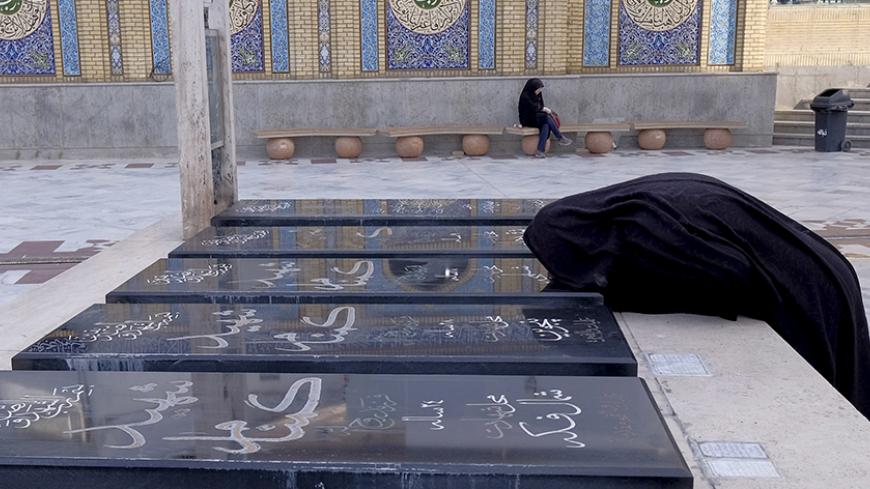 An Iranian woman kisses the grave of a person, who was killed during the Iran-Iraq war (1980-88), at a holy shrine in northern Tehran January 16, 2016. REUTERS/Raheb Homavandi/TIMA  ATTENTION EDITORS - THIS IMAGE WAS PROVIDED BY A THIRD PARTY. FOR EDITORIAL USE ONLY.   - RTX22MTY
