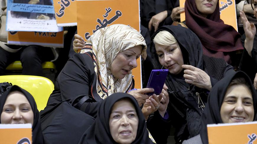 Women check the news on a mobile phone during a campaign gathering of candidates for the upcoming parliamentary elections mainly close to the reformist camp, in Tehran February 23, 2016. REUTERS/Raheb Homavandi/TIMA  ATTENTION EDITORS - THIS IMAGE WAS PROVIDED BY A THIRD PARTY. FOR EDITORIAL USE ONLY.   - RTX287F0