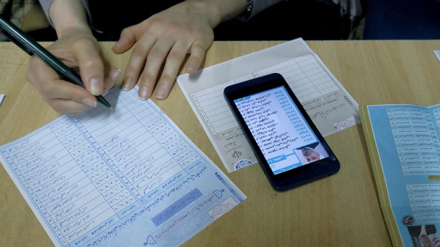 An Iranian woman fills in her ballot during elections for the parliament and a leadership body called the Assembly of Experts, which has the power to appoint and dismiss the supreme leader, in Tehran February 26, 2016. REUTERS/Raheb Homavandi/TIMA  ATTENTION EDITORS - THIS IMAGE WAS PROVIDED BY A THIRD PARTY. FOR EDITORIAL USE ONLY.  - RTX28SH7