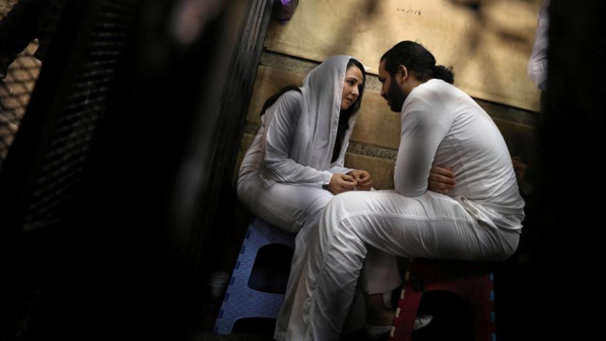 Aya Hijazi and her husband Mohamed Hassanein, founders of a non-governmental organisation that looks after street children, talk inside a holding cell as they face trial on charges of human trafficking, sexual exploitation of minors, and using children in protests, at a courthouse in Cairo, Egypt March 23, 2017. REUTERS/Mohamed Abd El Ghany - RTX32DVC