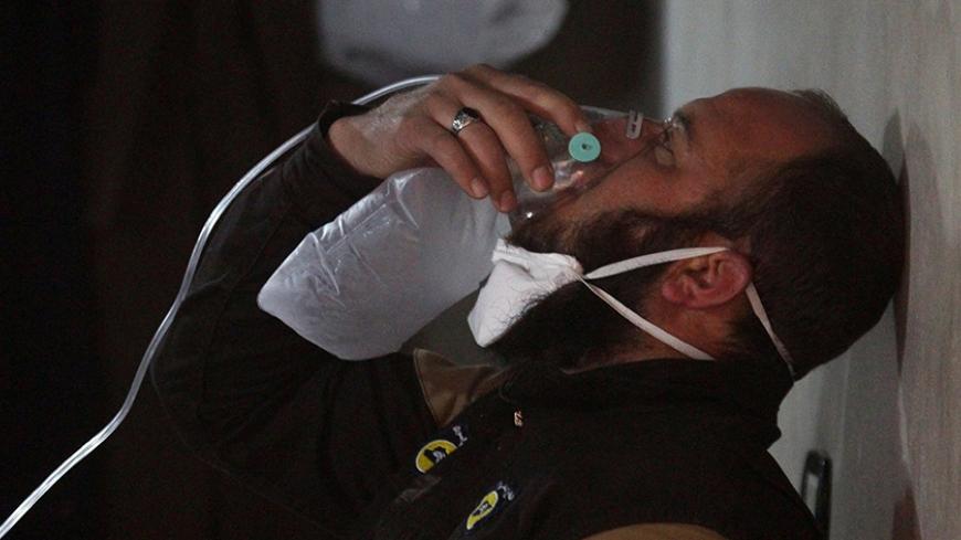 A civil defence member breathes through an oxygen mask, after what rescue workers described as a suspected gas attack in the town of Khan Sheikhoun in rebel-held Idlib, Syria April 4, 2017. REUTERS/Ammar Abdullah     TPX IMAGES OF THE DAY - RTX33ZAV