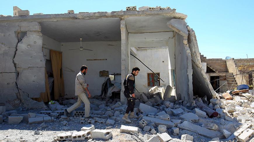 Civil defense members inspect the damage at a site hit by airstrikes on Tuesday, in the town of Khan Sheikhoun in rebel-held Idlib, Syria April 5, 2017. REUTERS/Ammar Abdullah - RTX3474G