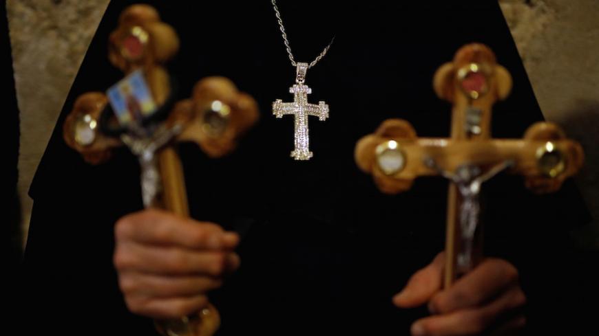 A worshipper holds crosses inside the Church of Holy Sepulchre during a Good Friday procession in Jerusalem's Old City April 14, 2017. REUTERS/Amir Cohen - RTX35J9I