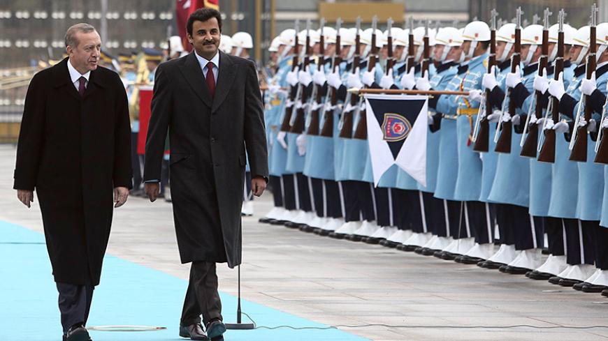 Qatari Crown Prince Sheikh Tamim bin Hamad bin Khalifa al-Thani (2ndL) and Turkish President Recep Tayyip Erdogan (L), walk past a guard of honor during an official welcoming ceremony prior to their meeting at the presidential palace in Ankara, Turkey, on December 19, 2014. AFP PHOTO / ADEM ALTAN        (Photo credit should read ADEM ALTAN/AFP/Getty Images)
