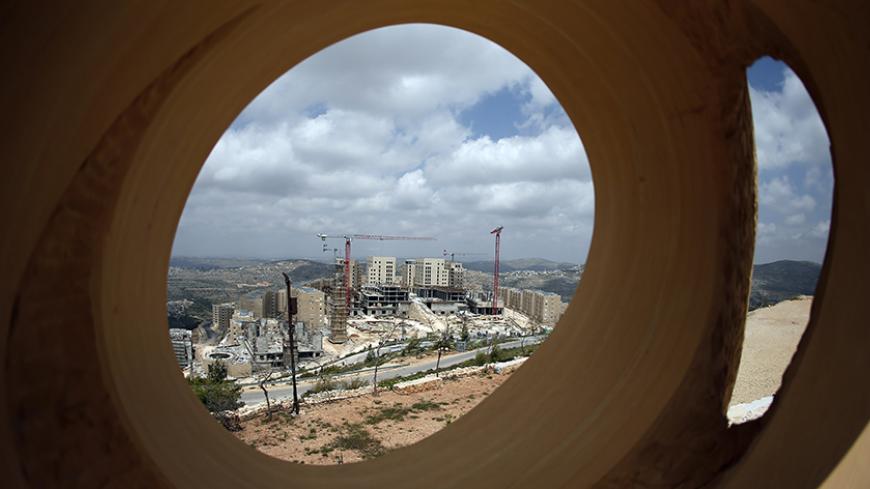 A picture shows a part of the new Palestinian city of Rawabi as seen through a sculpture, at the construction site of the new city just north of Ramallah in the West Bank, on April 22, 2015. Rawabi project, for 40.000 people apartments, is the first modern Palestinian city of its kind and described as the largest privately-funded development project in Palestinian history will can finally open its doors this May. AFP PHOTO / THOMAS COEX        (Photo credit should read THOMAS COEX/AFP/Getty Images)