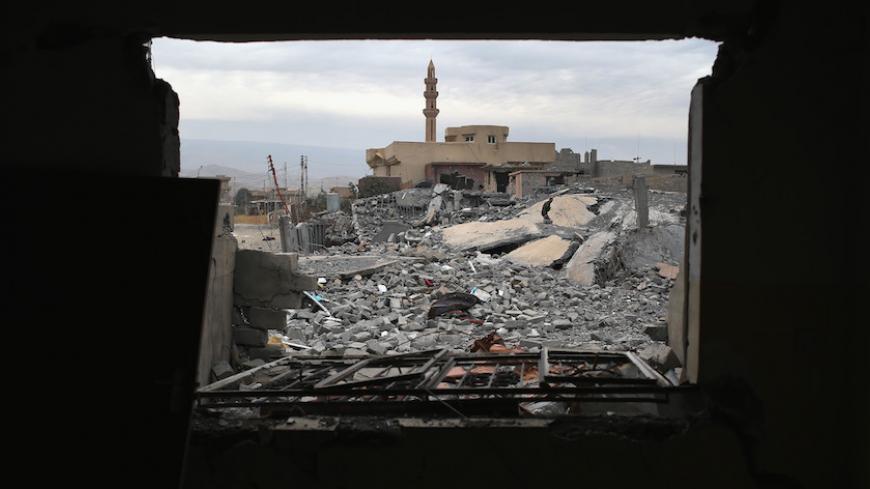 SINJAR, IRAQ - NOVEMBER 16:  A Kurdish Peshmerga soldier searches for weapons in the rubble of an airstrike near a mosque on November 16, 2015 in Sinjar, Iraq. Kurdish forces, with the aid of months of U.S.-led coalition airstrikes, liberated the town from ISIL extremists, known in Arabic as Daesh, in recent days. Although the battle was deemed a major victory, much of the city lay in complete ruins.  (Photo by John Moore/Getty Images)