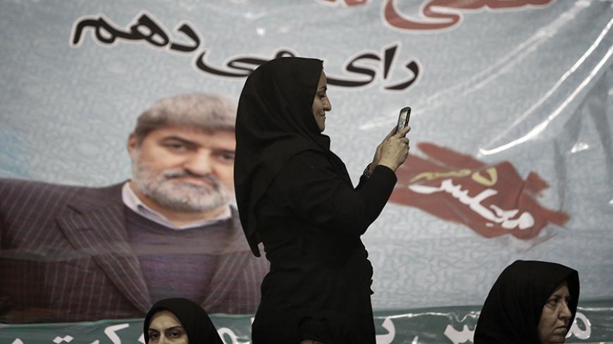 An Iranian woman takes pictures with her mobile phone in front of a portrait of Ali Motahari, a candidate for the upcoming parliamentary elections, during a campaign meeting in Tehran on February 23, 2016.
Iranians go to the polls on February 26, 2016 to elect a new 290-seat parliament and the powerful Assembly of Experts which supervises the work of supreme leader Ayatollah Ali Khamenei. / AFP / BEHROUZ MEHRI        (Photo credit should read BEHROUZ MEHRI/AFP/Getty Images)