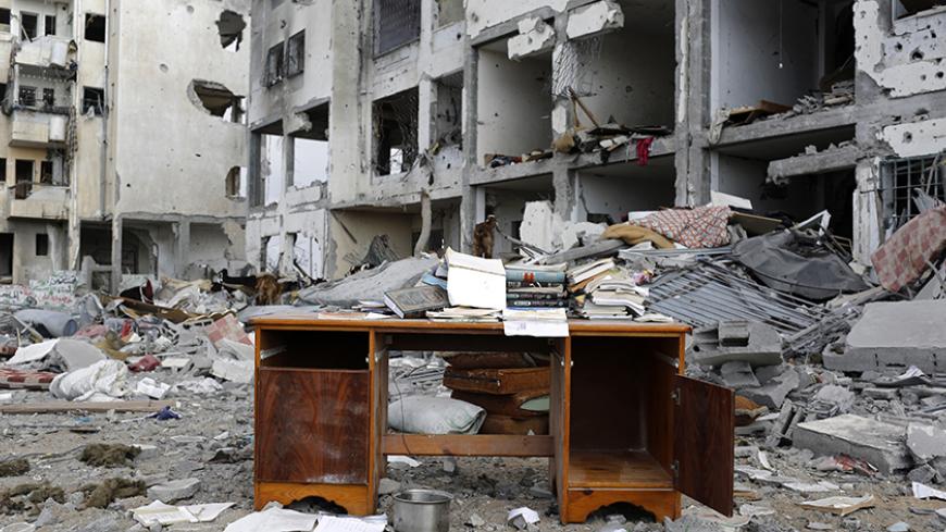 A desk sits amid the debris of buildings destroyed by what police said were Israeli airstrikes and shelling in the town of Beit Lahiya in the northern Gaza Strip August 3, 2014. Israel's month-long war against Hamas, with Israel carrying out air strikes, artillery bombardments and ground operations in response to constant militant rocket fire and attacks via tunnels, left more than 2,000 Palestinians dead, most of them civilians, as well as 64 Israeli soldiers and three civilians. It was the deadliest war i