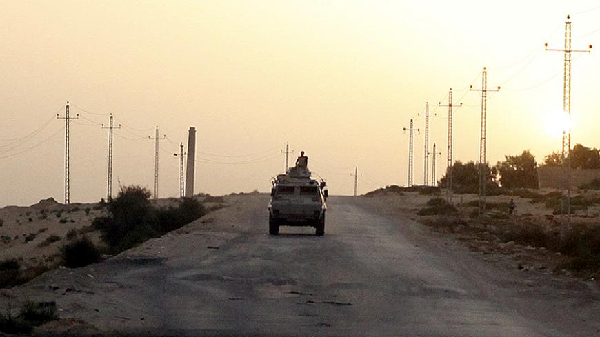 FILE PHOTO: An Egyptian military vehicle is seen on the highway in northern Sinai, Egypt, May 25, 2015.   To match Special Report EGYPT-POLITICS/SINAI      REUTERS/Asmaa Waguih/File Photo - RTS14RT4