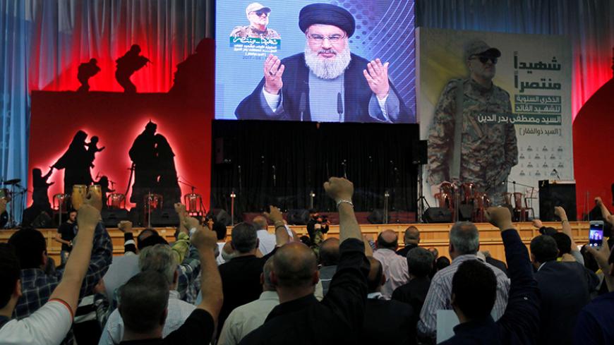 Hezbollah leader Sayyed Hassan Nasrallah addresses his supporters from a screen, during a ceremony marking a year after Hezbollah commander Mustafa Badreddine(picture on banner) was killed in an attack in Syria, in Beirut's southern suburbs, Lebanon May 11, 2017. REUTERS/Aziz Taher - RTS16886
