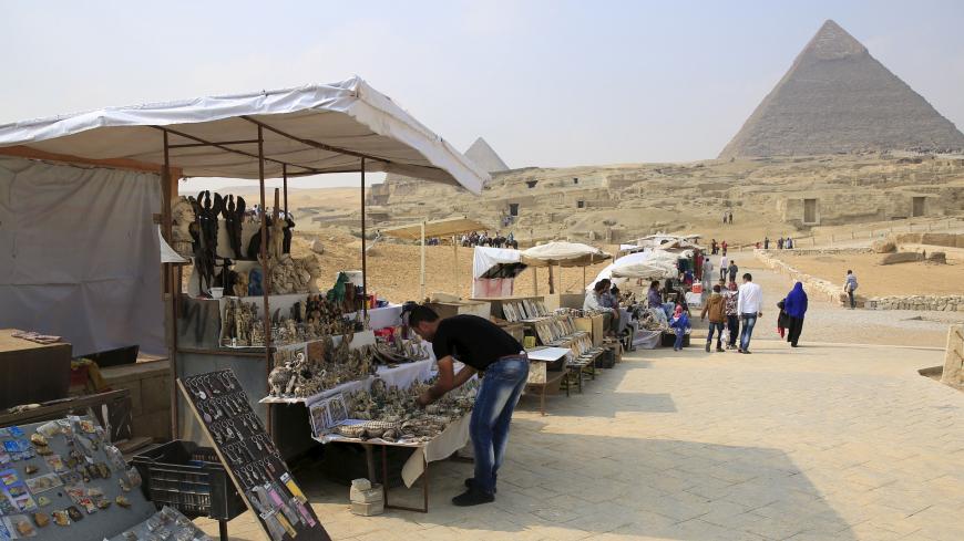 Souvenir vendors wait for tourists in front of the Giza pyramids on the outskirts of Cairo, Egypt, November 8, 2015. Egypt's Tourism Minister Hesham Zaazou said Cairo regretted the suspension of flights and was doing all it could to secure its airports and tourist sites, adding that he would fly to Sharm al-Sheikh to oversee measures to support tourists there. REUTERS/Amr Abdallah Dalsh - RTS60A4
