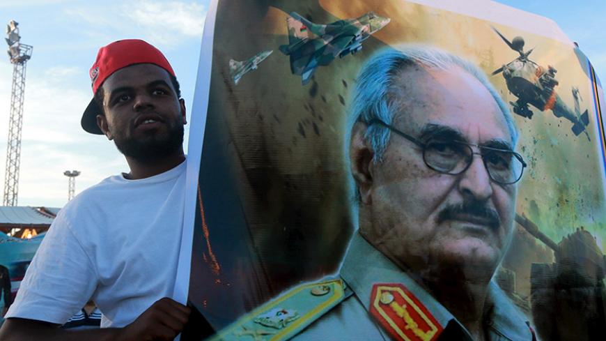 A man holds a picture of General Khalifa Haftar during a demonstration in support of the Libyan army under the leadership of General Khalifa in Benghazi, Libya November 6, 2015. REUTERS/Esam Omran Al-Fetori - RTX1V2OW