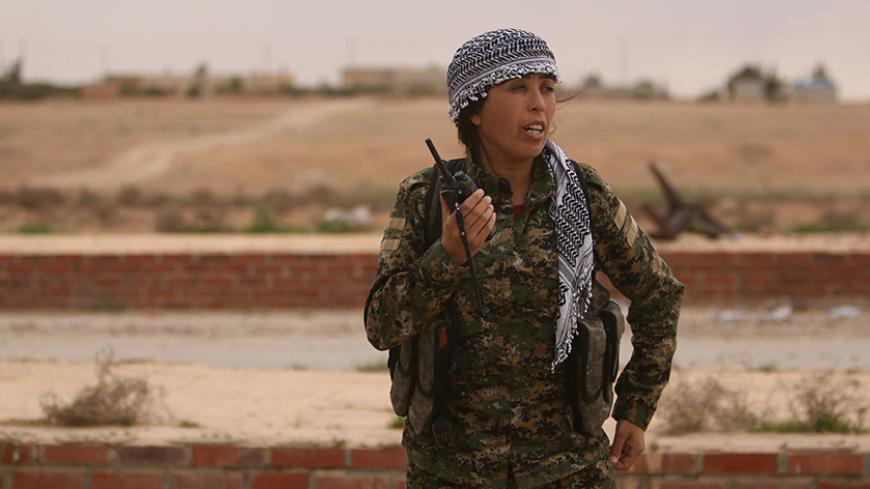 Rojda Felat, commander of a U.S.-backed operation by Kurdish and Arab fighters to capture the Syrian city of Raqqa, uses her walkie talkie near the Taqba Dam, west of Raqqa, Syria March 30, 2017. Picture taken March 30, 2017. To match Interview MIDEAST-CRISIS/SYRIA-RAQQA REUTERS/Rodi Said - RTX33I1G