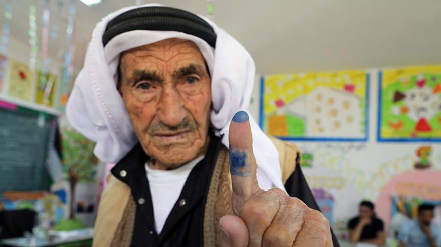 A Palestinian man shows his ink-stained finger after casting his ballot at a polling station during municipal elections in the West Bank village of Yatta, near Hebron May 13, 2017. REUTERS/Ammar Awad - RTX35MU6