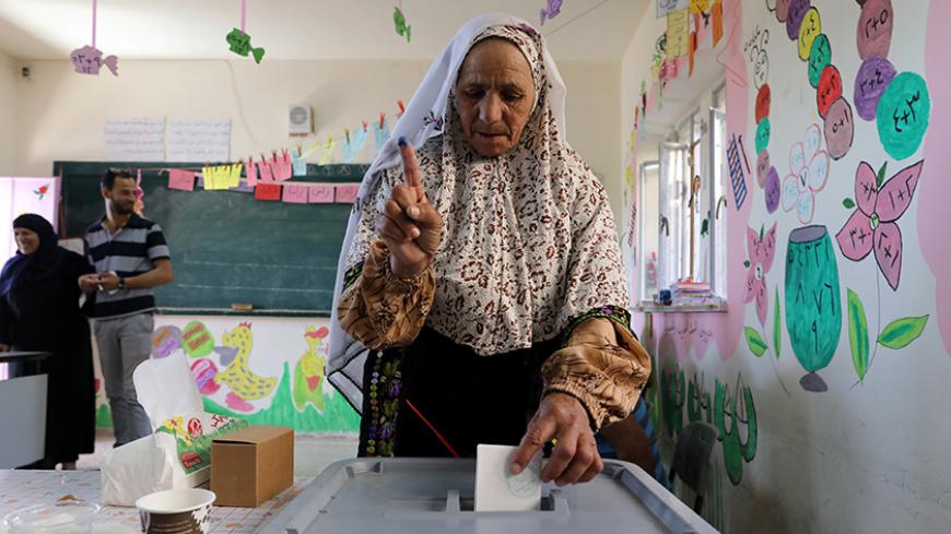 A Palestinian woman casts her ballot at a polling station during municipal elections in the West Bank village of Yatta, near Hebron May 13, 2017. REUTERS/Ammar Awad      TPX IMAGES OF THE DAY - RTX35N3A