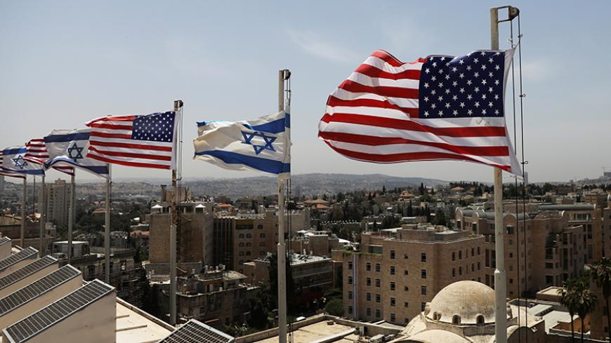 American and Israeli flags flutter in the wind atop the roof of the King David Hotel, in preparation for the upcoming visit of U.S. President Donald Trump to Israel, in Jerusalem May 17, 2017. REUTERS/Ronen Zvulun - RTX36DS2