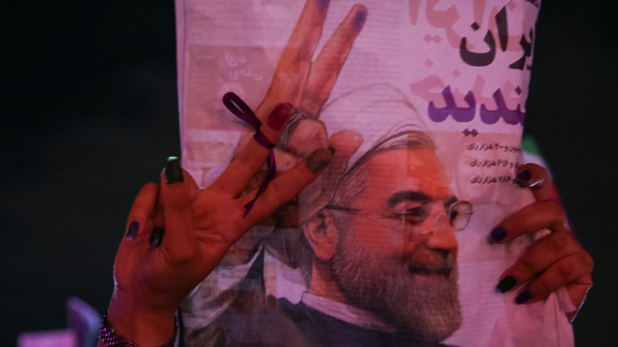 A supporter of Iranian president Hassan Rouhani holds his poster as she celebrates his victory in the presidential election, in Tehran, Iran, May 20, 2017. TIMA via REUTERS ATTENTION EDITORS - THIS IMAGE WAS PROVIDED BY A THIRD PARTY. FOR EDITORIAL USE ONLY.      TPX IMAGES OF THE DAY - RTX36RDP