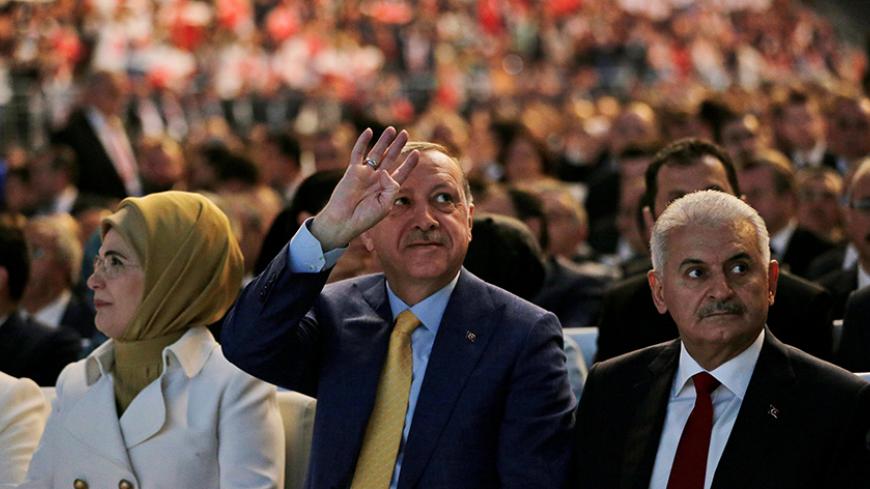 Turkey's President Recep Tayyip Erdogan, accompanied by his wife Emine, and Turkey's Prime Minister Binali Yildirim, waves to supporters during the congress of the ruling Justice and Development Party (AKP) in Ankara, Turkey, May 21, 2017. REUTERS/Burhan Ozbilici/Pool - RTX36SZA