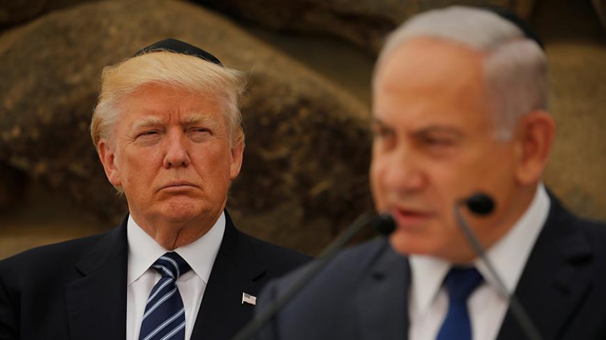 Israeli Prime Minister Benjamin Netanyahu talks on a podium as U.S. President Donald Trump listens during a ceremony commemorating the six million Jews killed by the Nazis in the Holocaust, in the Hall of Remembrance at Yad Vashem Holocaust memorial in Jerusalem May 23, 2017.  REUTERS/Jonathan Ernst - RTX376QY