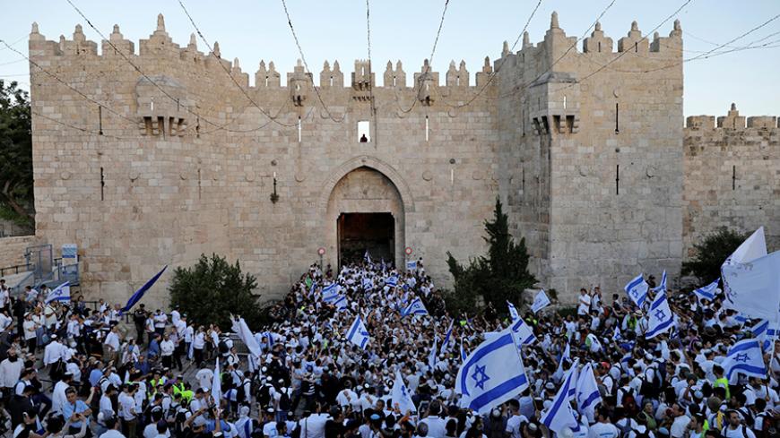 Israelis celebrate as they hold Israeli flags during a parade marking Jerusalem Day, the day in the Jewish calendar when Israel captured East Jerusalem and the Old City from Jordan during the 1967 Middle East War, just outside Damascus Gate outside Jerusalem's Old City May 24, 2017. REUTERS/Ronen Zvulun - RTX37G3U