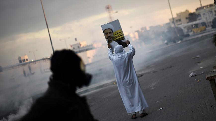 TOPSHOT - A Bahraini protester holds a placard depicting a portrait of Sheikh Ali Salman, head of the Shiite opposition movement al-Wefaq, during clashes with riot police following a protest against Salman's arrest in the village of Sitra, south of the capital Manama, on January 29, 2016. / AFP / MOHAMMED AL-SHAIKH        (Photo credit should read MOHAMMED AL-SHAIKH/AFP/Getty Images)