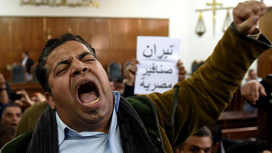 Egyptians react on December 19, 2016 at the high administrative court as a judge announces the postponing of a court ruling in the case of two Red Sea islands to January 16, 2017, in the capital Cairo. The writing in Arabic reads ''Tiran and Sanafir are Egyptian''.
An Egyptian court suspended on September 29, 2016 a previous ruling freezing the controversial transfer of two Red Sea islands to Saudi Arabia, which had provoked protests when announced earlier this year. In June, an administrative court had ove