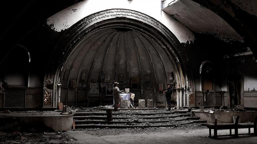 Members of the Nineveh Plain Protection Units (NPU), a small Christian militia charged with protecting the predominantly Christian Iraqi town of Qaraqosh (Hamdaniya), pray in a destroyed church in the town which lies some 30 kilometres east of the northern city of Mosul on March 3, 2017.
Qaraqosh was ravaged by IS jihadists, who seized it in June 2014 as they rampaged across parts of northern Iraq, capturing second city Mosul and swathes of the area known as the Nineveh Plain, home to much of the county's d
